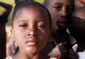 A young girl and an older man are standing together.