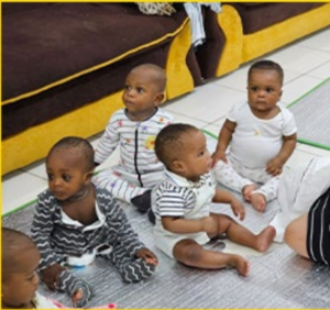 A group of babies sitting on the floor